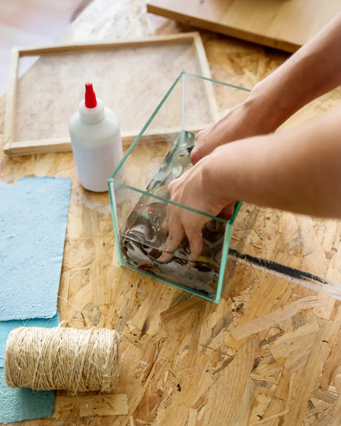 Die Hand einer Frau löst zerrissenes Papier im Wasser auf.