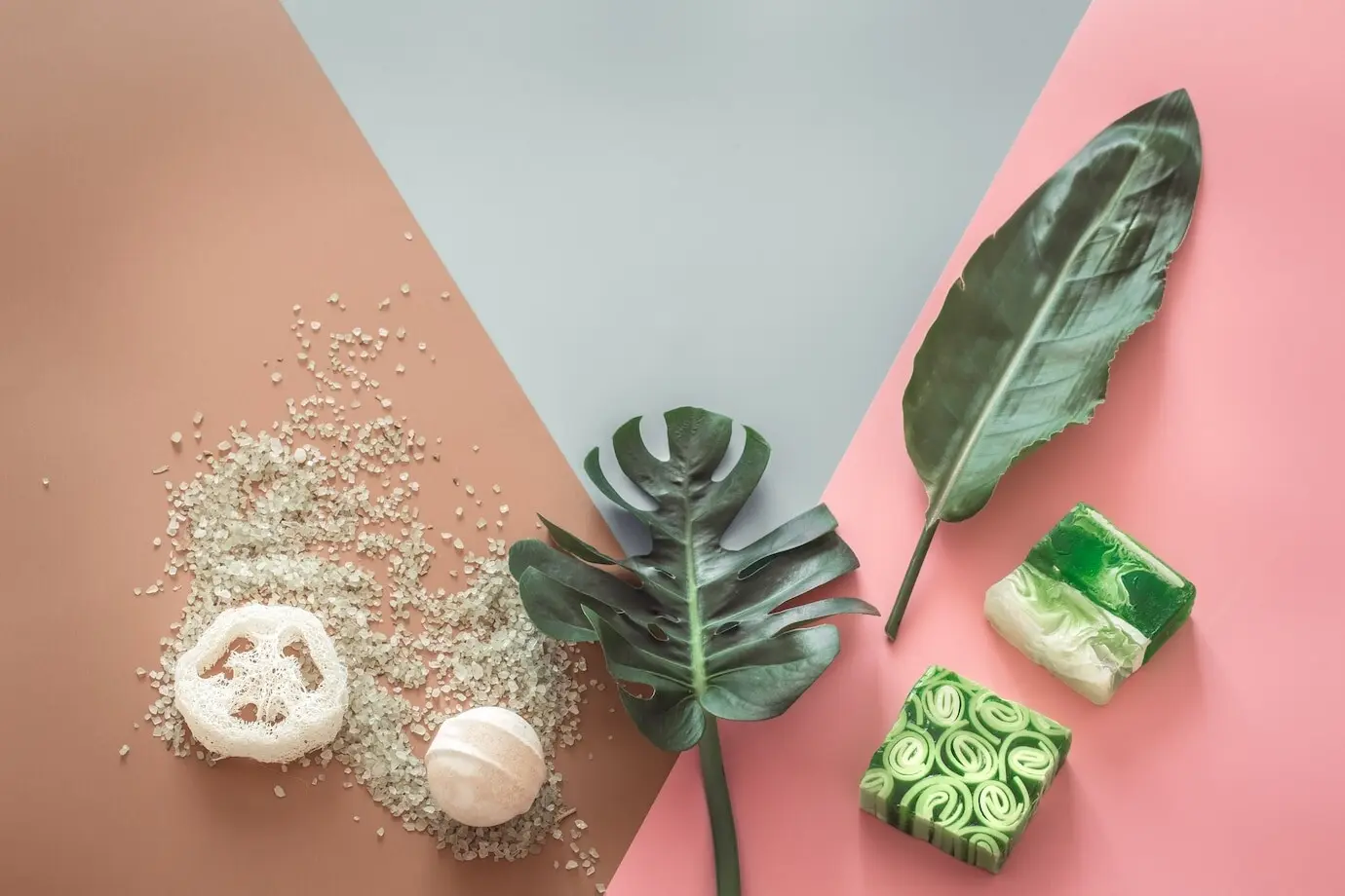 Spa-Komposition mit Körperpflegeartikeln vor einer farbigen Wand.